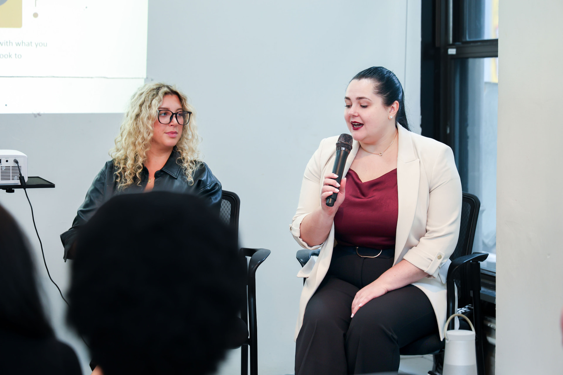 Galina Fendikevich speaking on stage at an AI Week New York session, seen from the audience